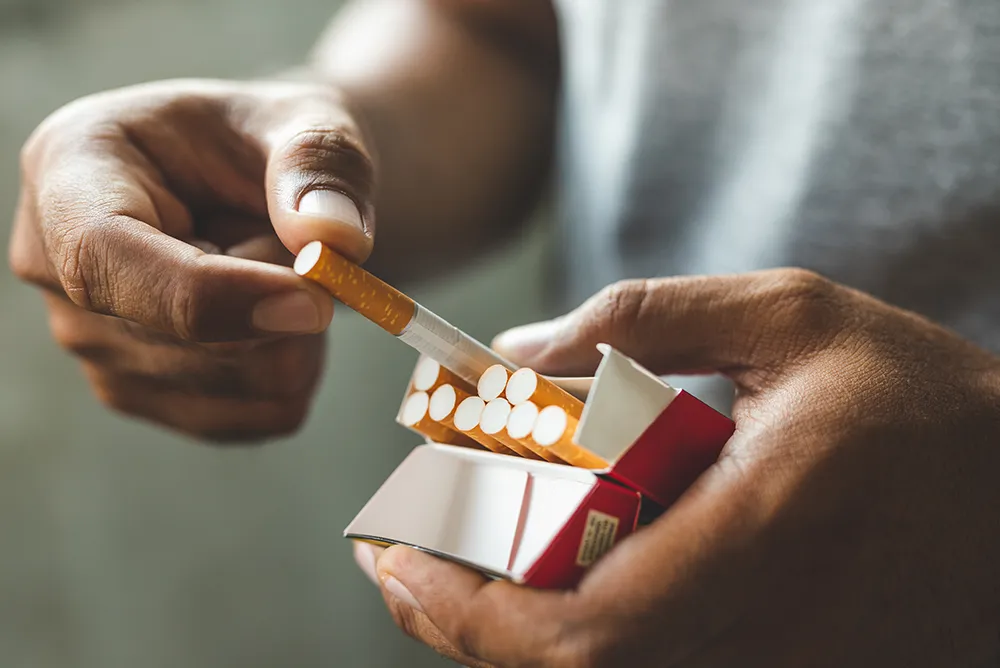 Personne tenant une cigarette, illustrant l&rsquo;impact du tabac sur la sant&eacute; cardiovasculaire